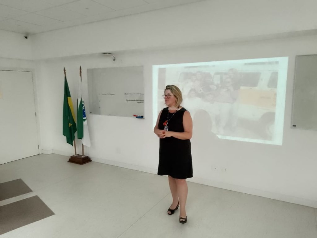 Professora de vestido preto em palestra aos acadêmicos